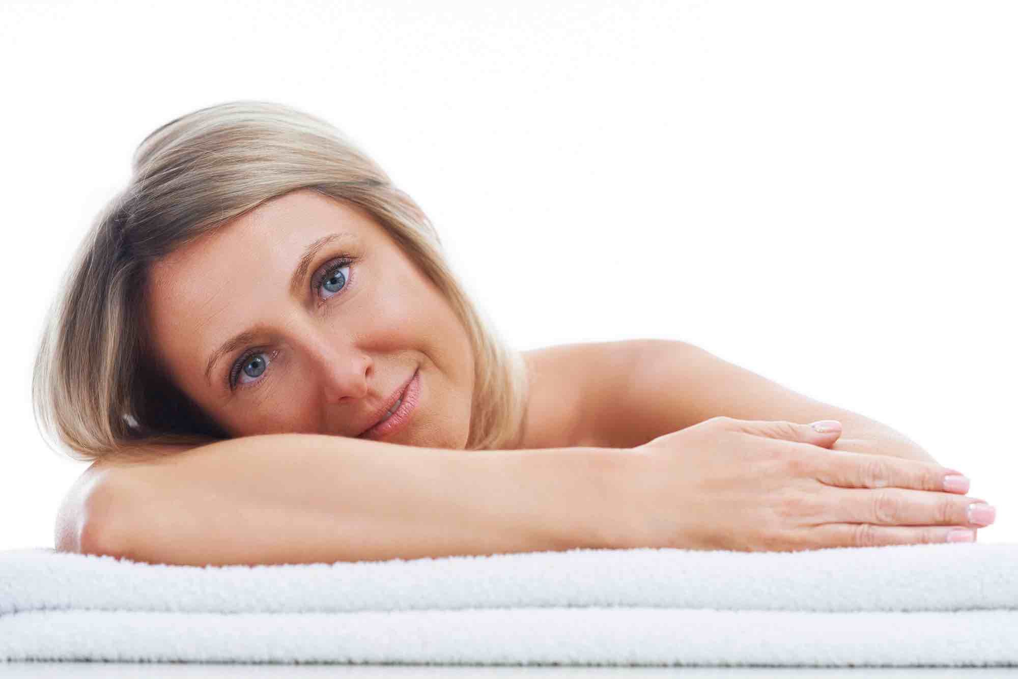 Woman resting head on arm and towels